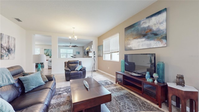 living room with ceiling fan with notable chandelier