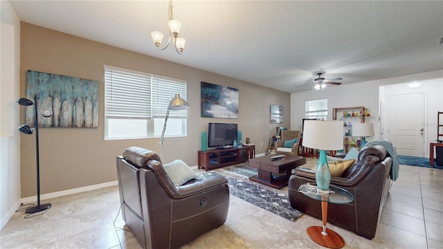 living room with ceiling fan with notable chandelier and light tile patterned floors