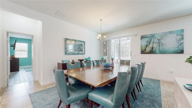 dining room featuring a notable chandelier, light tile patterned floors, and a wealth of natural light