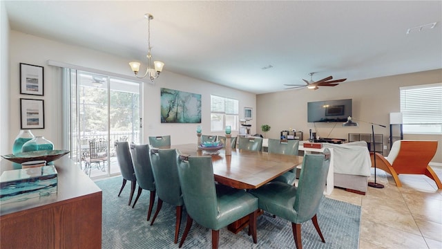 tiled dining area with ceiling fan with notable chandelier