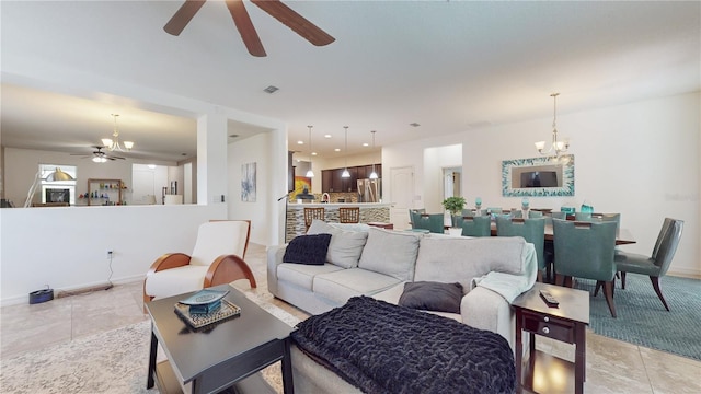 living room with light tile patterned floors and ceiling fan with notable chandelier