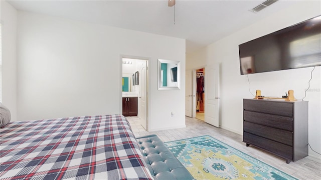 bedroom featuring connected bathroom and light hardwood / wood-style floors