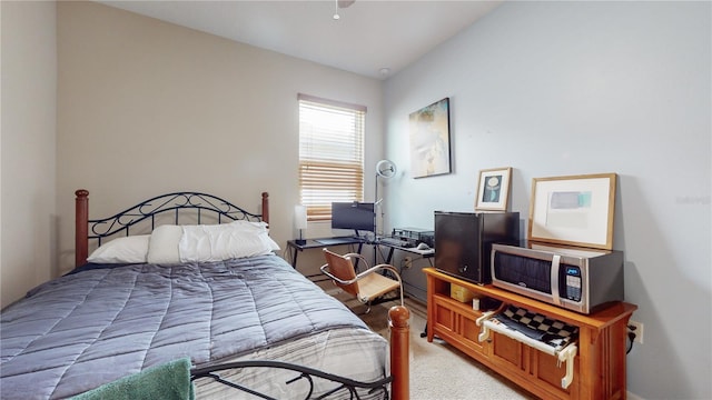 bedroom featuring light colored carpet and vaulted ceiling