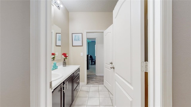 bathroom with tile patterned flooring, vanity, and a textured ceiling