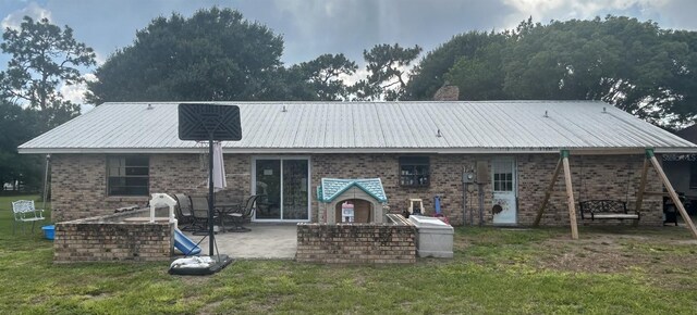 back of property with a lawn and a patio