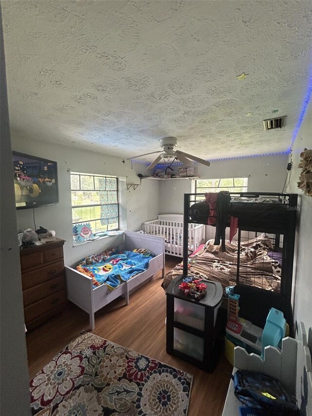 bedroom featuring ceiling fan, a textured ceiling, and hardwood / wood-style flooring