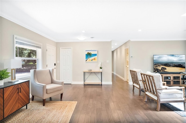 living area with hardwood / wood-style flooring and crown molding