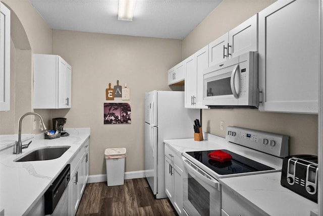 kitchen featuring light stone countertops, sink, white cabinets, and white appliances