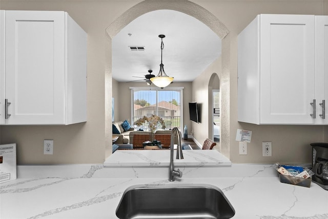 kitchen featuring white cabinetry, sink, and light stone counters