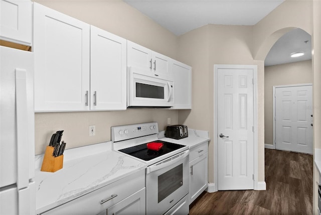 kitchen featuring dark hardwood / wood-style flooring, white appliances, light stone countertops, and white cabinets