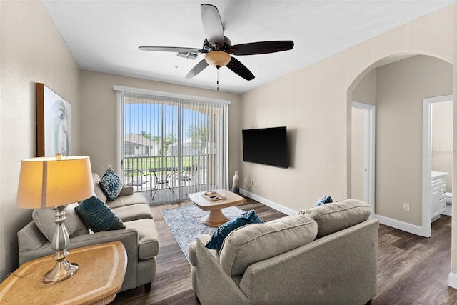 living room with ceiling fan and dark hardwood / wood-style flooring