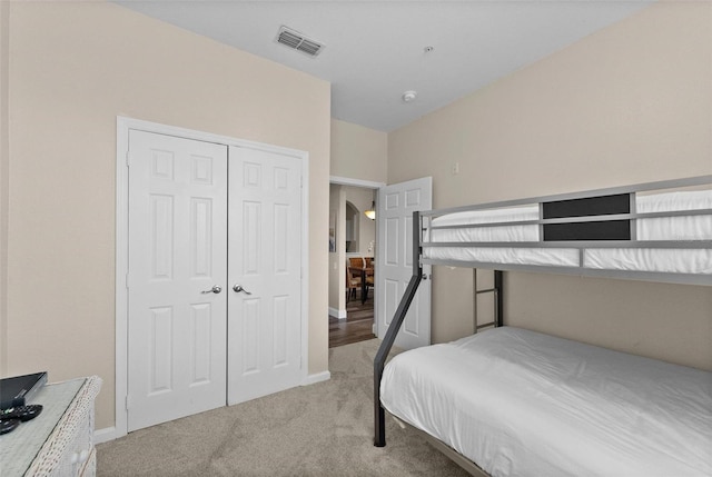 bedroom featuring light carpet and a closet