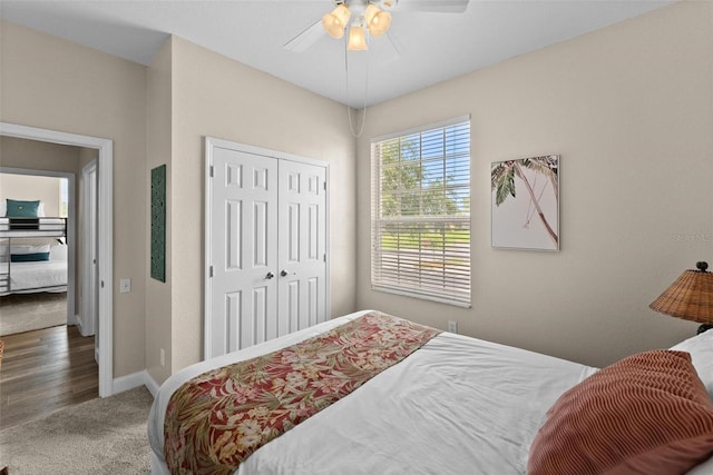 carpeted bedroom with ceiling fan and a closet