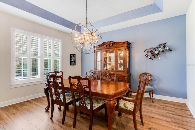 dining space featuring light hardwood / wood-style flooring and a notable chandelier