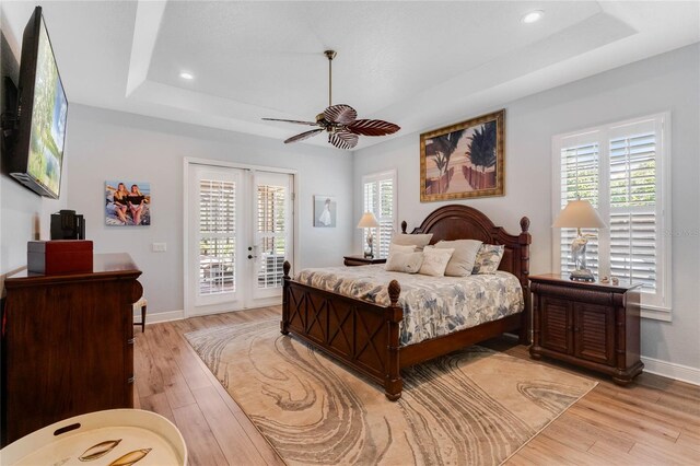 bedroom with access to exterior, light hardwood / wood-style floors, and multiple windows