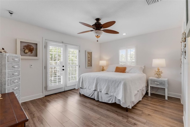 bedroom featuring access to outside, multiple windows, ceiling fan, and hardwood / wood-style flooring