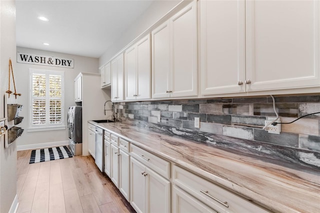 kitchen featuring stainless steel dishwasher, light hardwood / wood-style floors, and white cabinetry