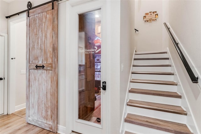 stairs featuring hardwood / wood-style floors and a barn door