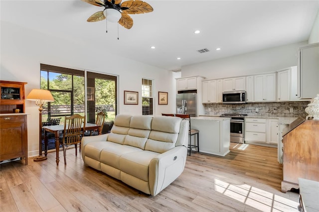 living room with ceiling fan and light hardwood / wood-style flooring