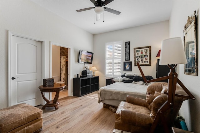 bedroom with ceiling fan, light hardwood / wood-style floors, and connected bathroom