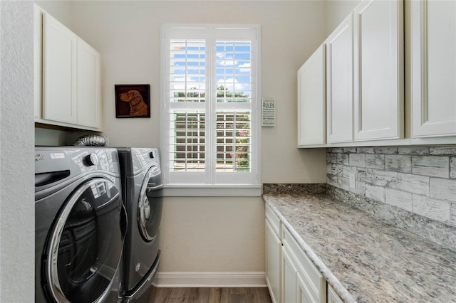 laundry room with cabinets, washing machine and dryer, dark hardwood / wood-style floors, and plenty of natural light