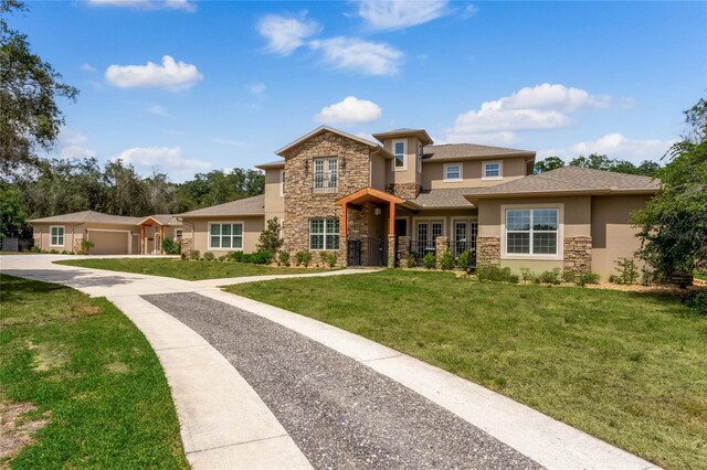 prairie-style house featuring a garage and a front lawn