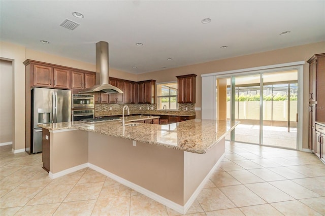 kitchen featuring stainless steel refrigerator with ice dispenser, island exhaust hood, a large island, and light stone countertops