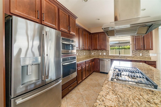 kitchen featuring sink, light stone counters, tasteful backsplash, island exhaust hood, and stainless steel appliances