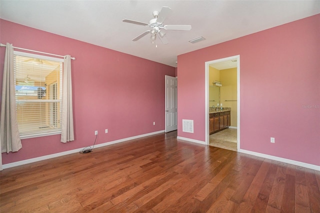 unfurnished bedroom with ceiling fan, hardwood / wood-style floors, and ensuite bath