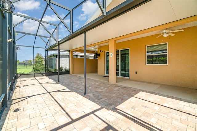 view of patio / terrace featuring ceiling fan and glass enclosure