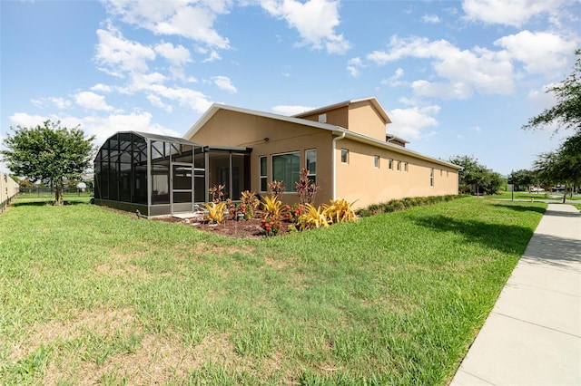 view of home's exterior with a yard and glass enclosure