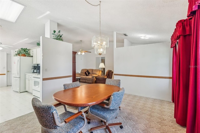 dining space featuring vaulted ceiling, a textured ceiling, and ceiling fan with notable chandelier