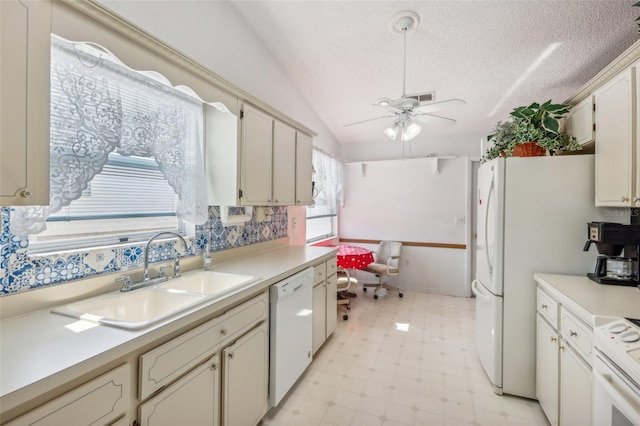 kitchen featuring a textured ceiling, white appliances, ceiling fan, sink, and lofted ceiling