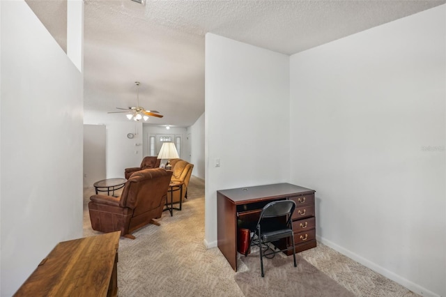 carpeted office with ceiling fan and a textured ceiling