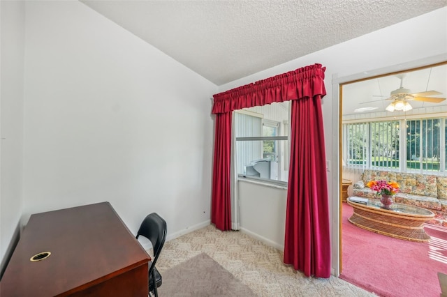 office featuring a textured ceiling, light colored carpet, vaulted ceiling, and ceiling fan