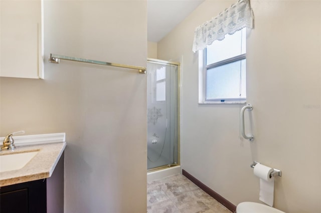 bathroom featuring vanity, toilet, and a shower with shower door