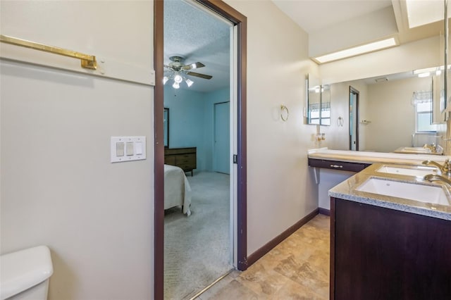 bathroom featuring vanity, ceiling fan, toilet, and a textured ceiling