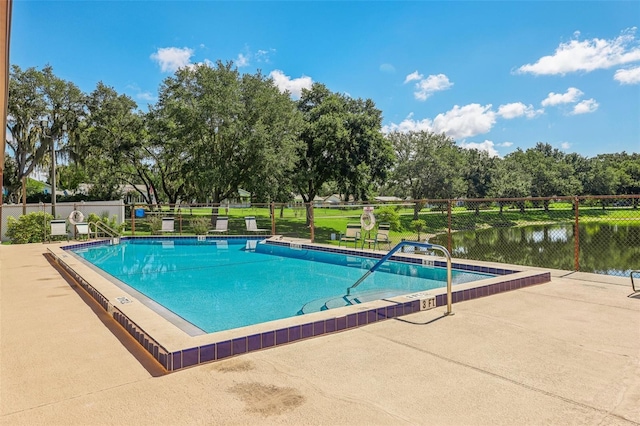 view of pool featuring a water view and a patio