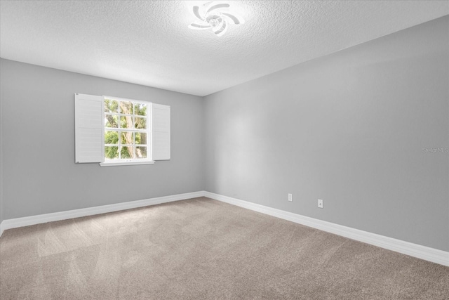 carpeted empty room featuring a textured ceiling