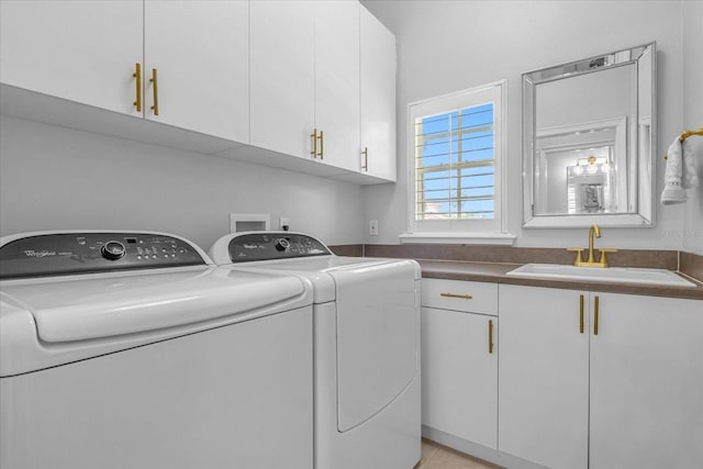 washroom with washer and clothes dryer, sink, and cabinets