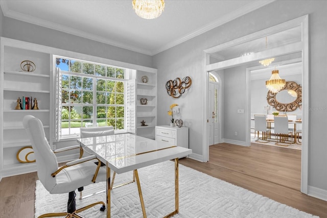 office area featuring built in shelves, crown molding, light hardwood / wood-style floors, and a notable chandelier