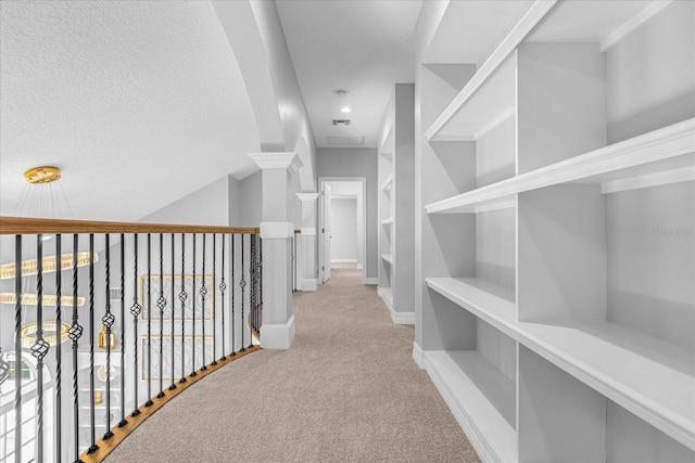 hall with a textured ceiling and light carpet