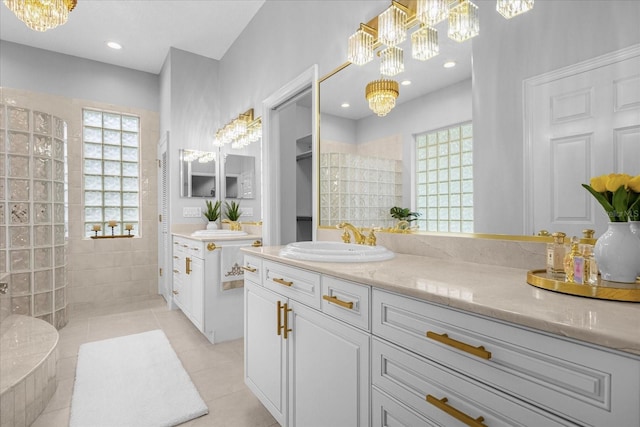 bathroom with tile patterned floors, vanity, walk in shower, and a notable chandelier