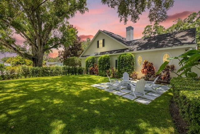 yard at dusk with a patio and an outdoor fire pit