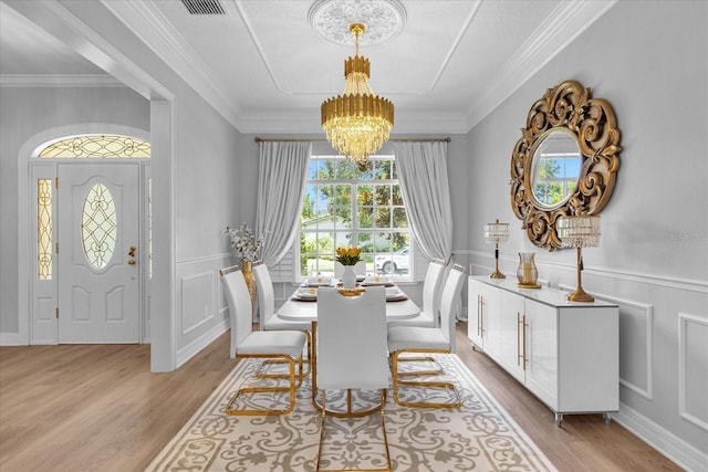 dining space with a chandelier, light hardwood / wood-style flooring, and crown molding