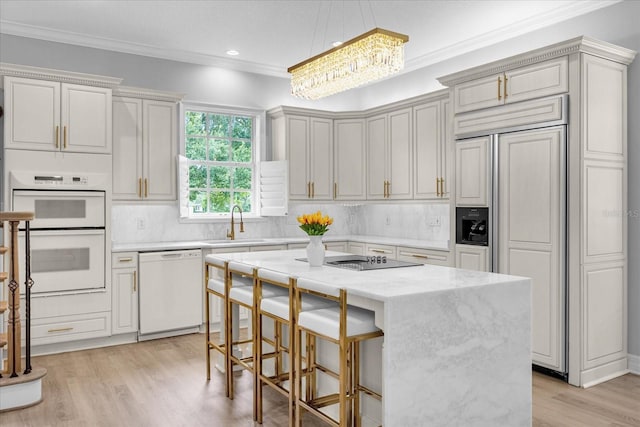 kitchen with pendant lighting, white appliances, tasteful backsplash, a kitchen island, and light stone counters