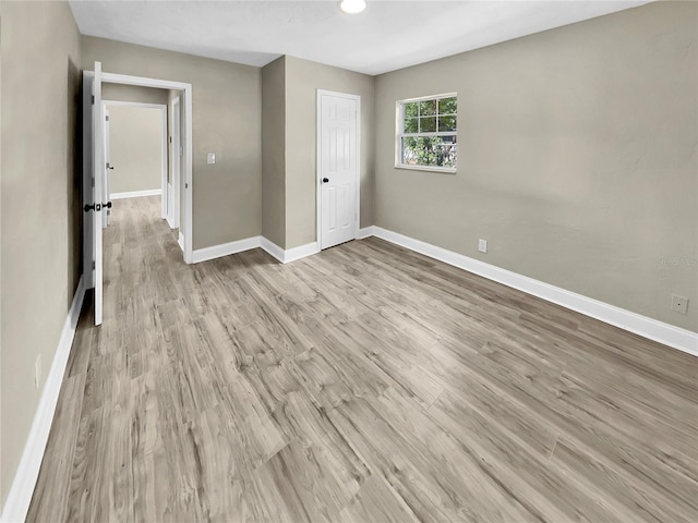 unfurnished bedroom with a closet and light wood-type flooring