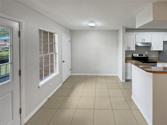 kitchen featuring stainless steel range with electric stovetop, white cabinets, and light tile patterned flooring