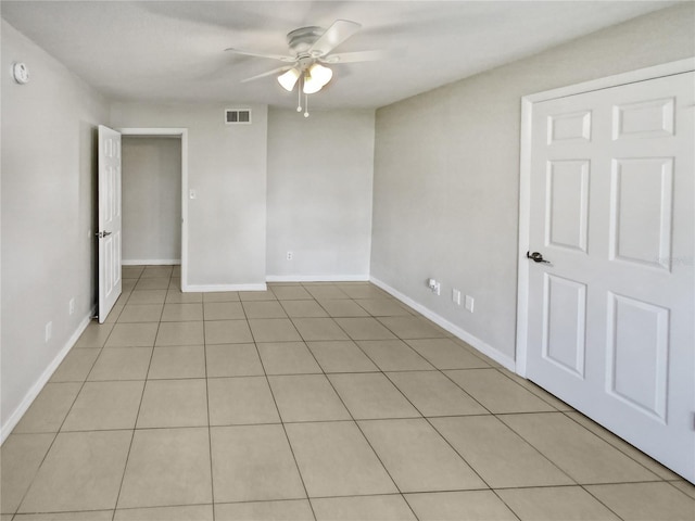 tiled spare room featuring ceiling fan