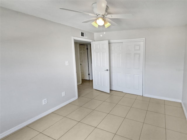 unfurnished bedroom featuring ceiling fan, a closet, and light tile patterned flooring